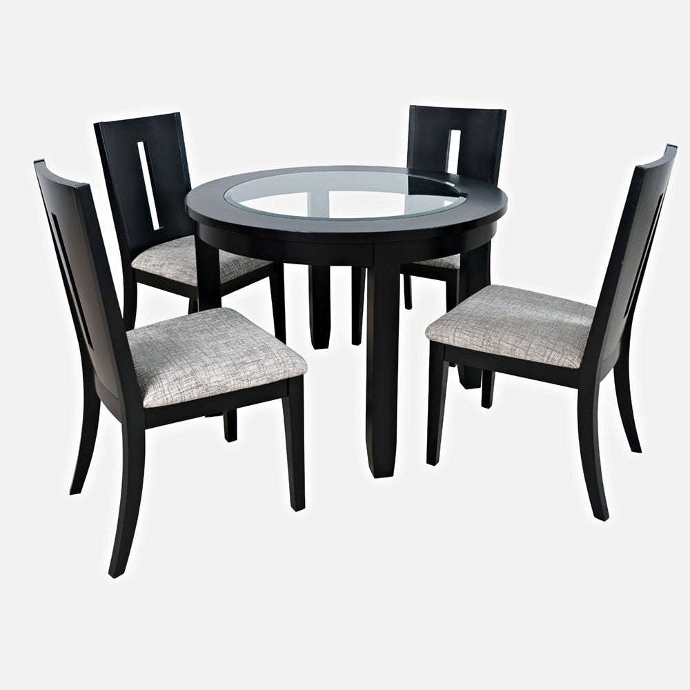 Round glass table with four black chairs and gray cushions.