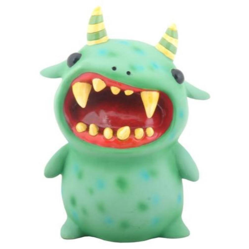 A green monster toy with yellow horns and sharp teeth.