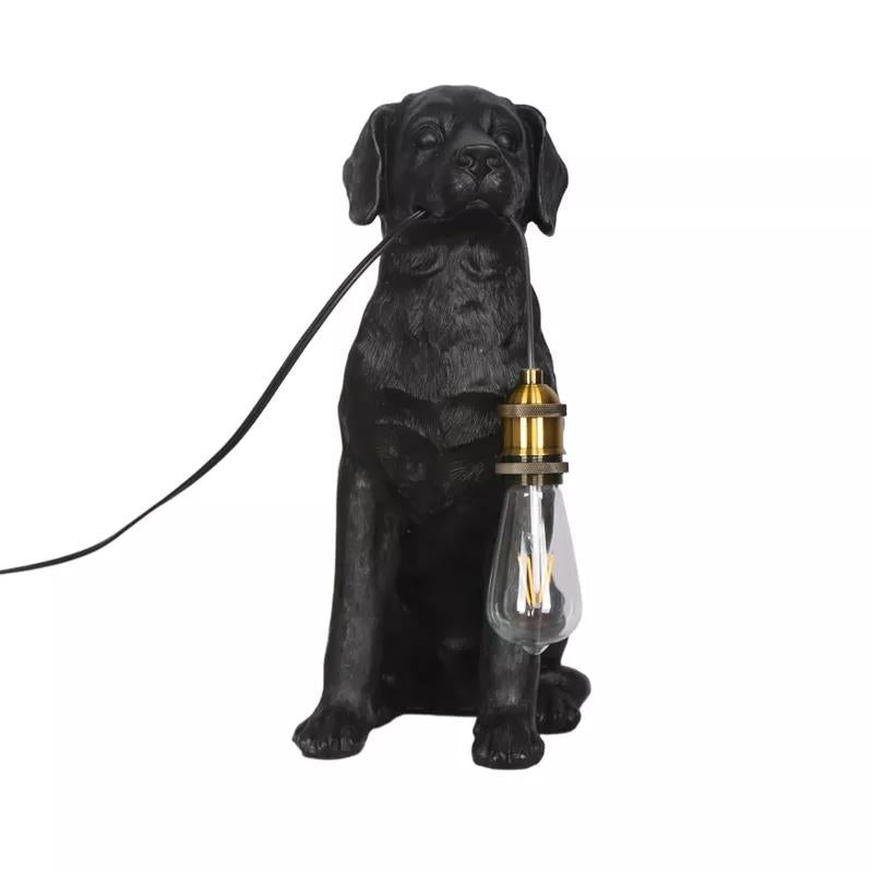 Dog lamp with a vintage bulb hanging from its mouth.