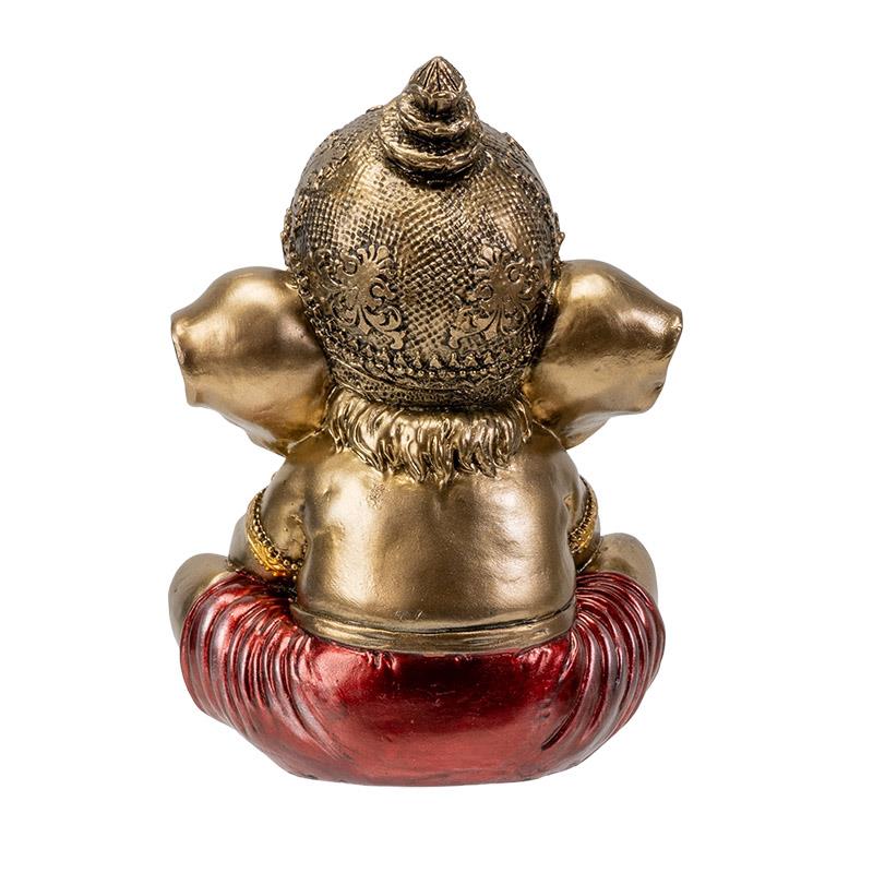 Golden elephant statue facing backward with intricate headpiece and red garment.