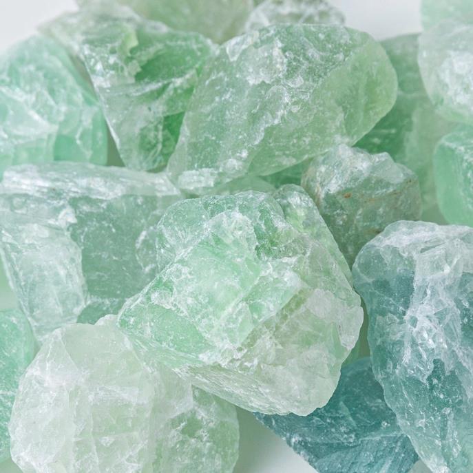 Pale green raw crystals clustered together.