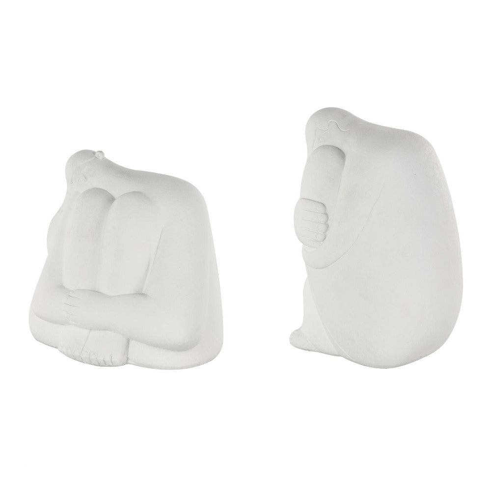 Two white abstract sculptures of seated figures with rounded shapes.