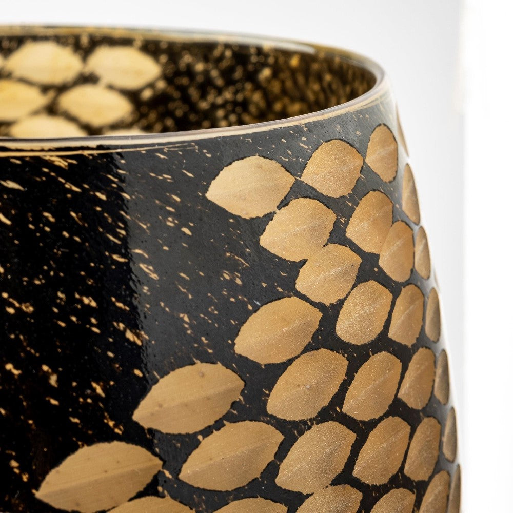 Close-up of a black vase with gold leaf patterns.