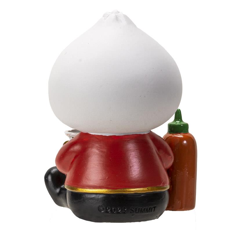Red-vested figurine with a white round head, accompanied by a hot sauce bottle.