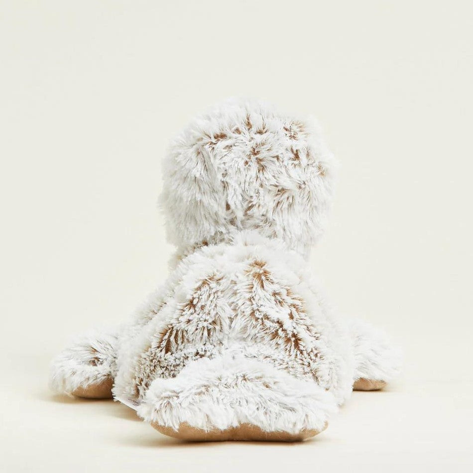 Fluffy stuffed animal facing away on a light background.