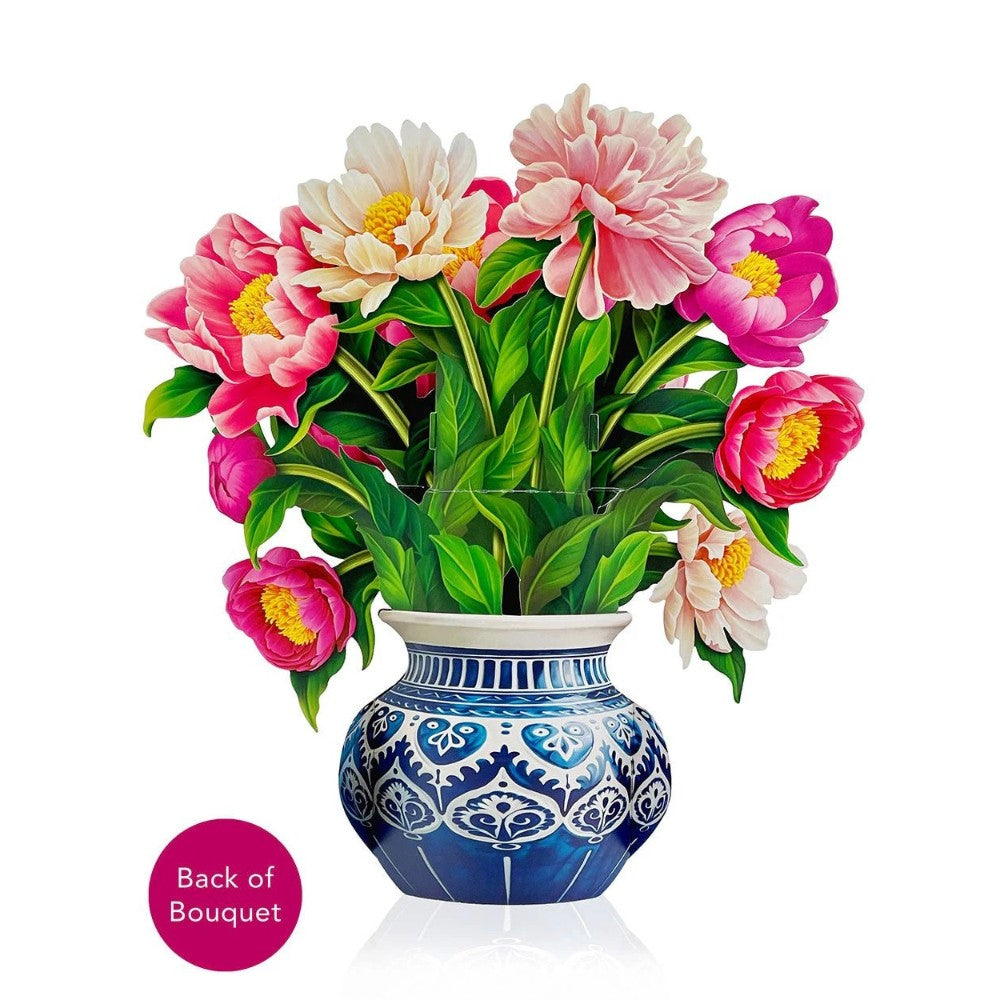 Blue vase with vibrant pink flowers and lush green leaves.