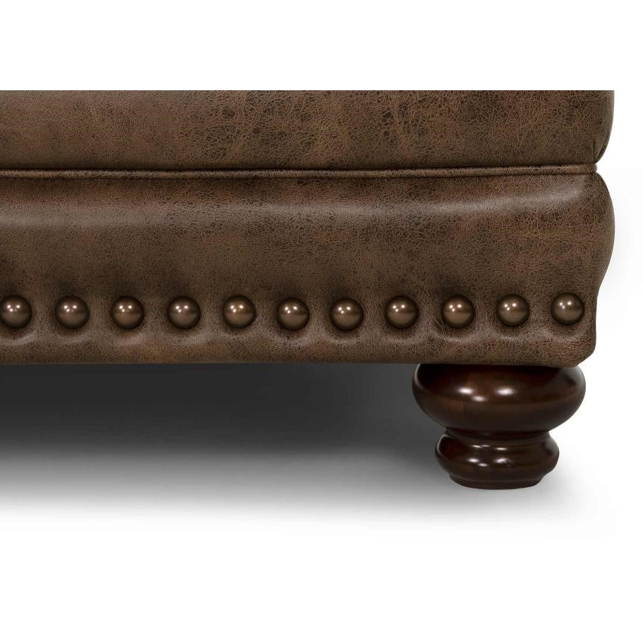Brown leather furniture with studded trim and wooden leg.