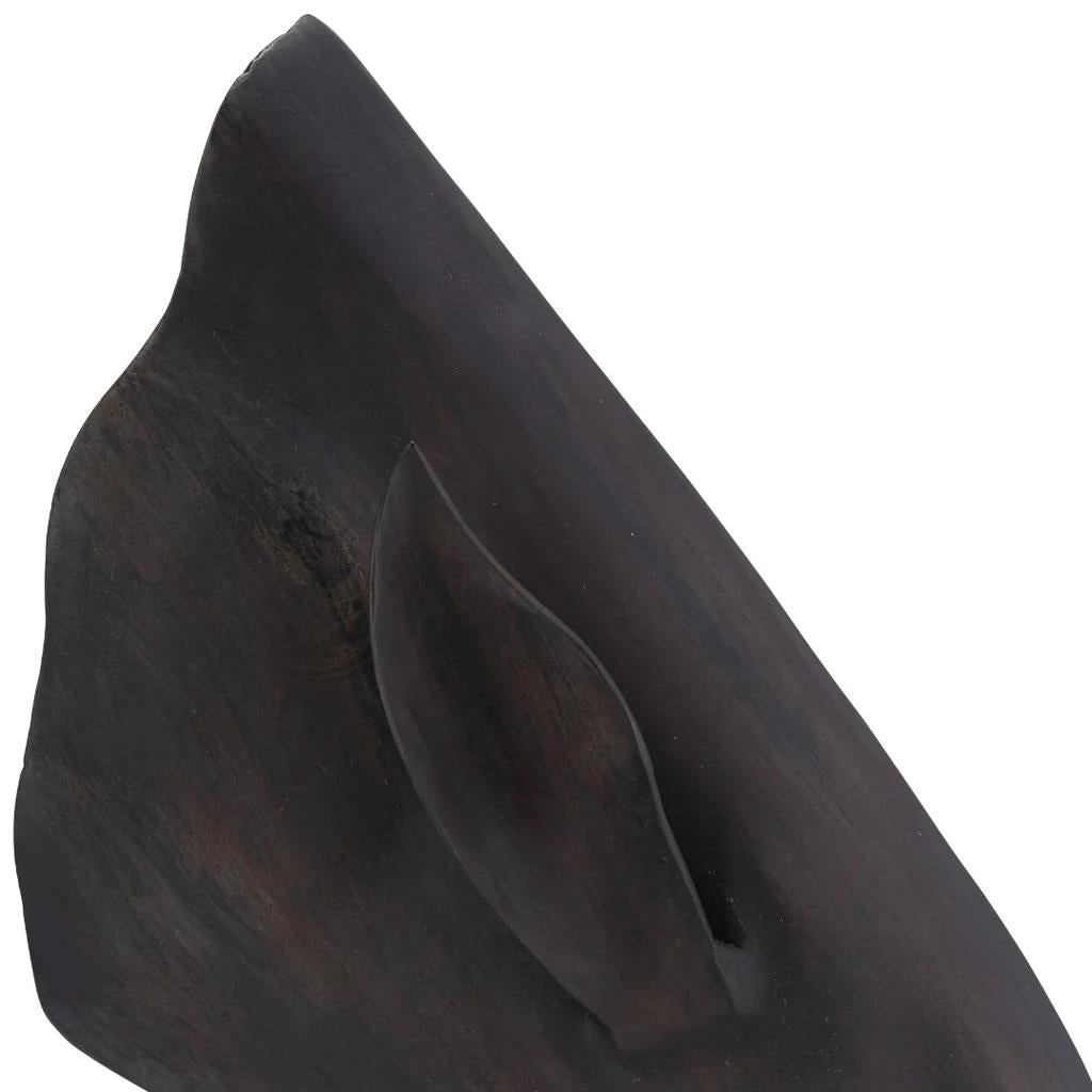 Close-up of a dark wooden animal sculpture with an ear detail.