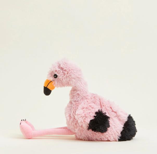 Plush pink flamingo with black accents sitting on a light background.
