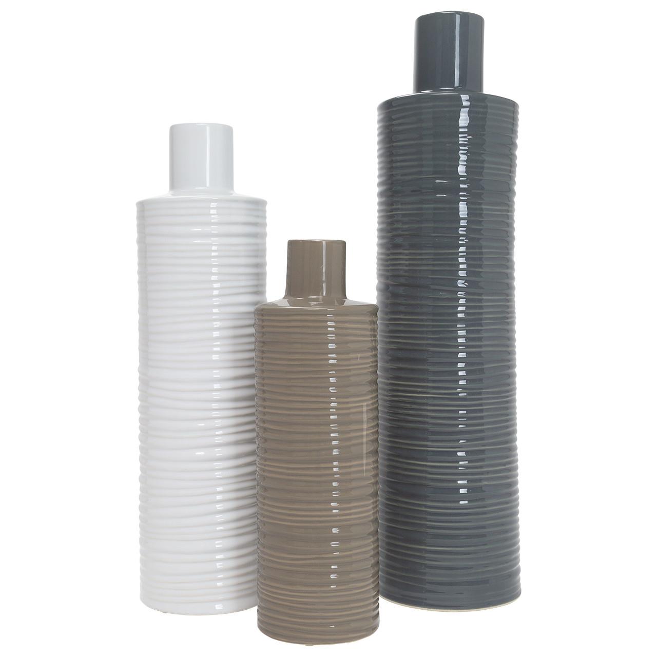 Three tall, ribbed ceramic vases in white, brown, and gray.
