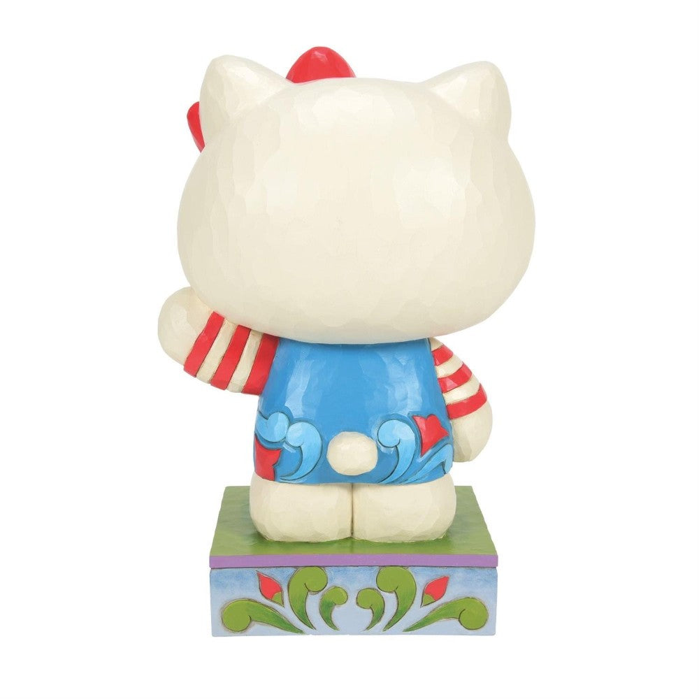 Decorative cat figurine facing away, wearing a colorful outfit.