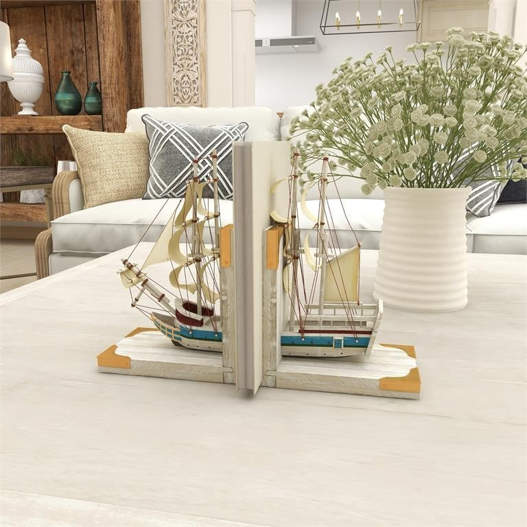 Decorative ship bookends on a table with flowers in a cozy living room.