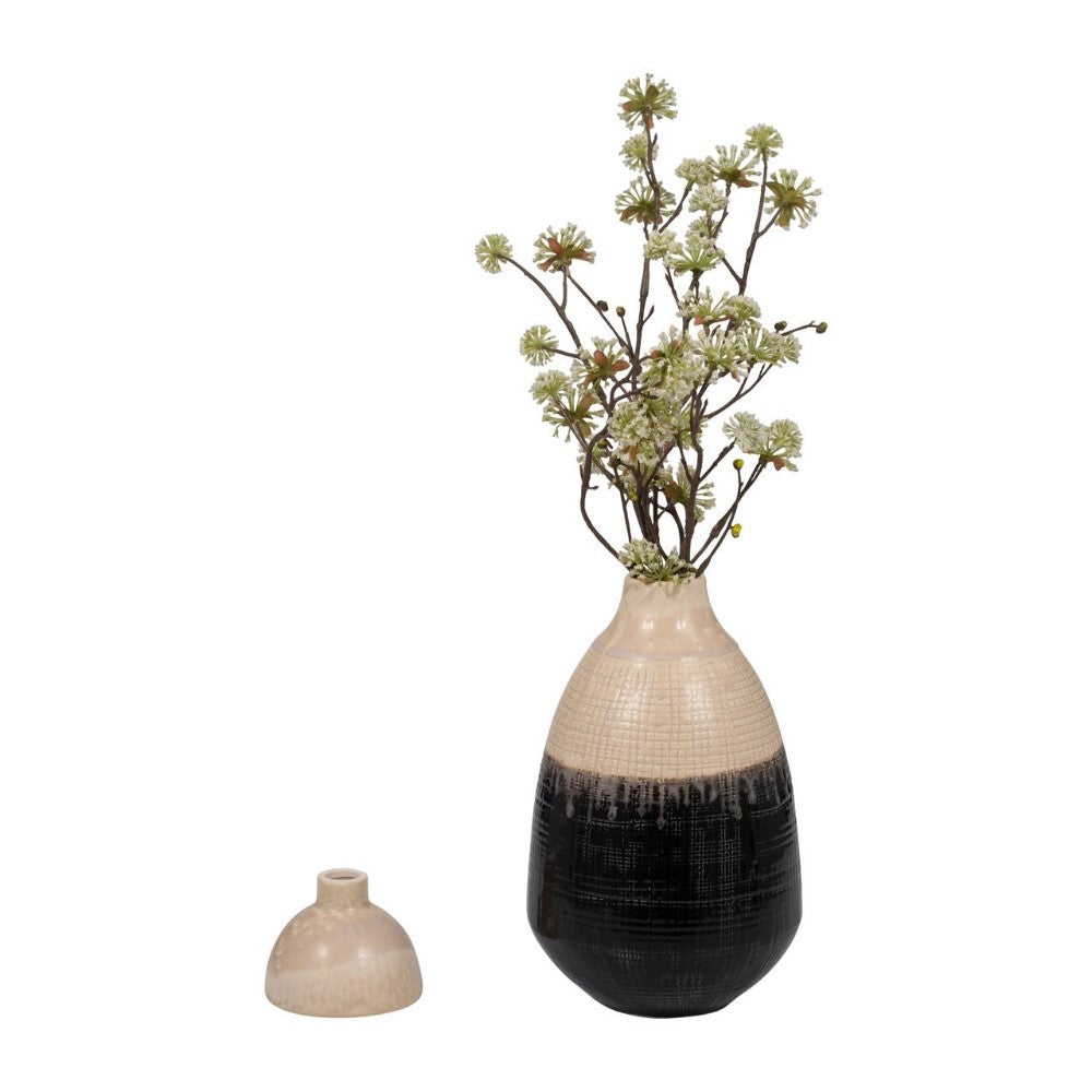 Ceramic vase with dried flowers, and separate vase lid nearby.