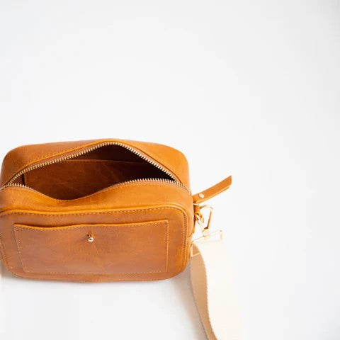 Tan leather bag with open zipper on a white background.
