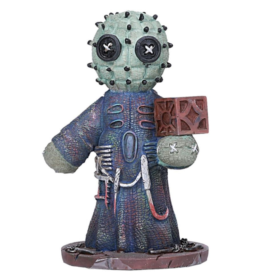 Cactus-like figure with button eyes and a textured robe holding a detailed block.