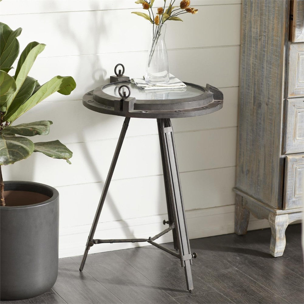 Industrial table with vase beside a plant and cabinet.