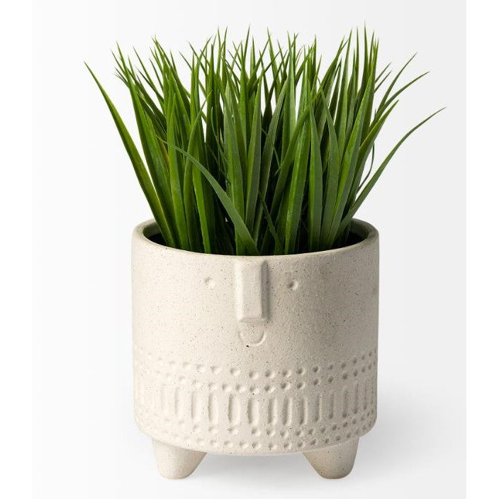 White, textured face planter with green grass-like plant.