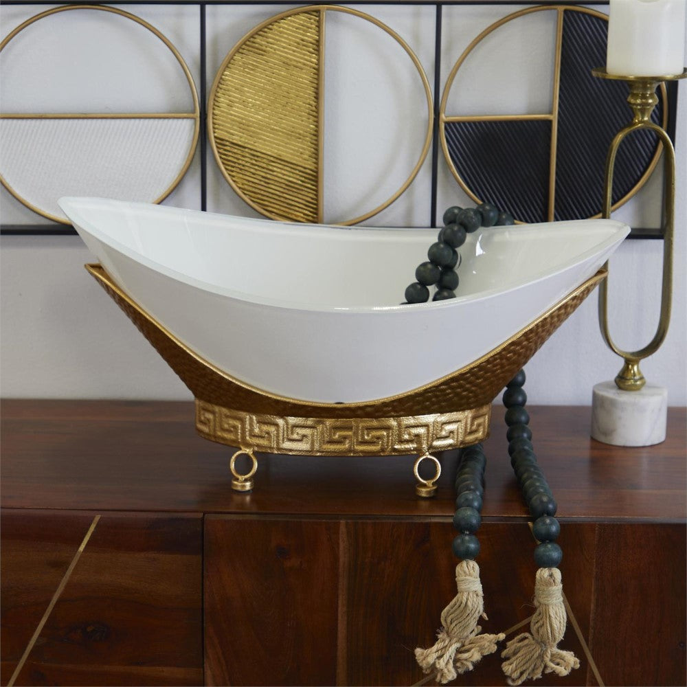 Elegant decor with a white bowl, gold accents, beads, and geometric wall art.
