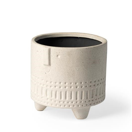 Beige textured planter with three legs and a minimalist face design.