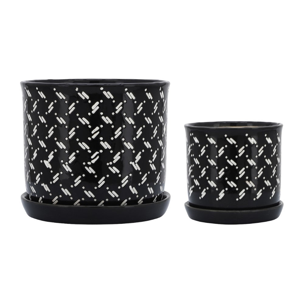 Two black pots with white geometric patterns and matching saucers.