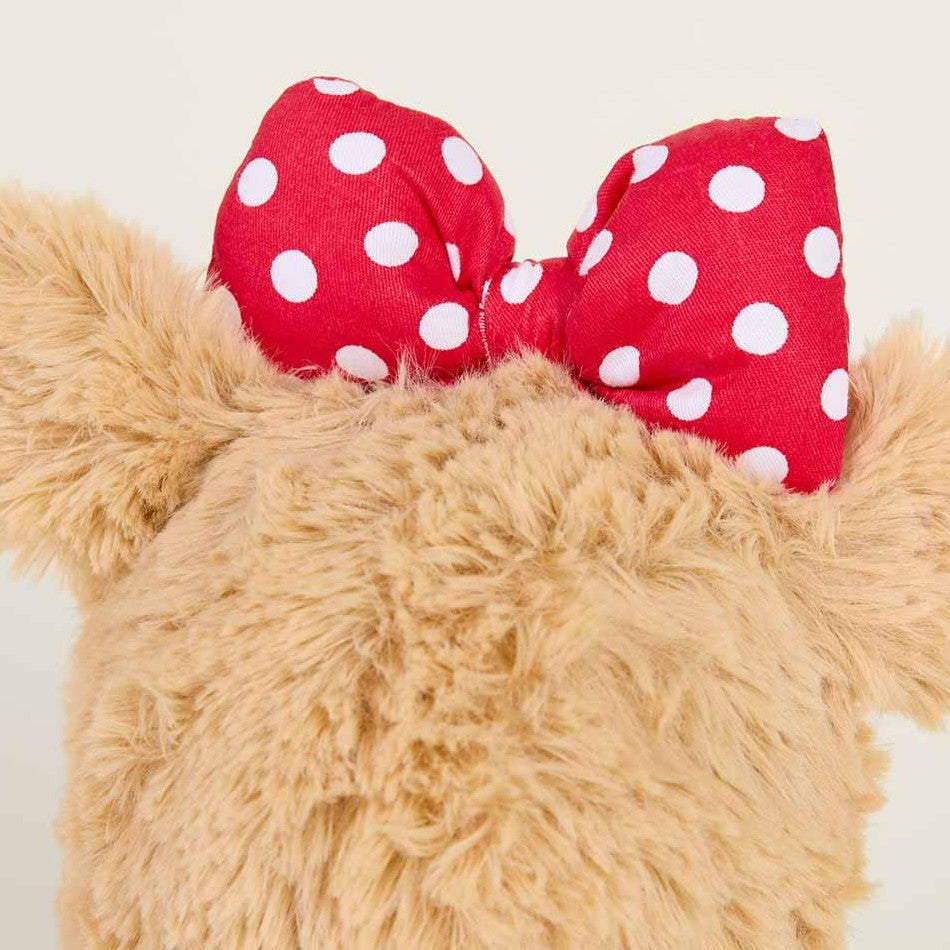 Fluffy bear with red polka dot bow on its head.