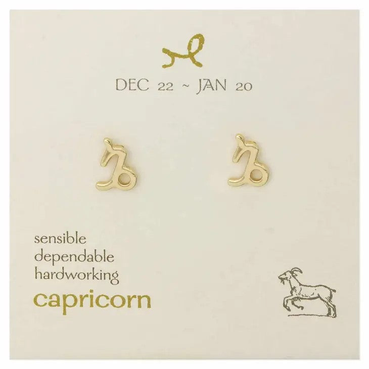Capricorn earrings with dates and traits on a display card.