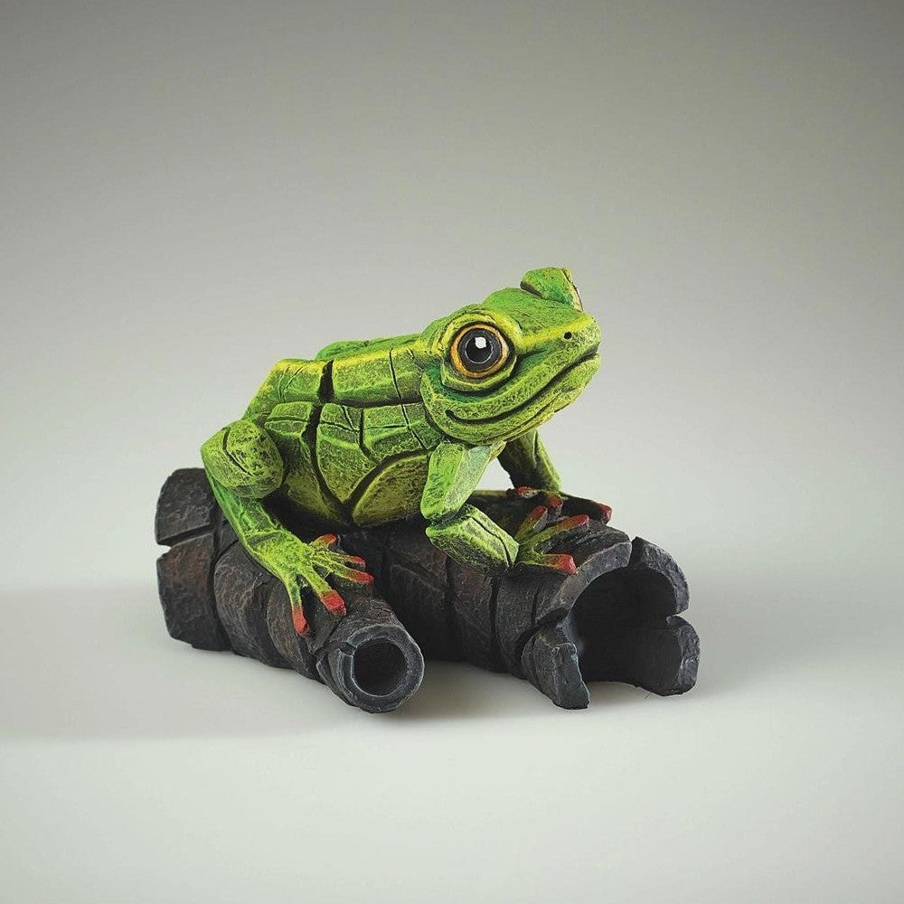 Green robotic frog sculpture on dark tubes.