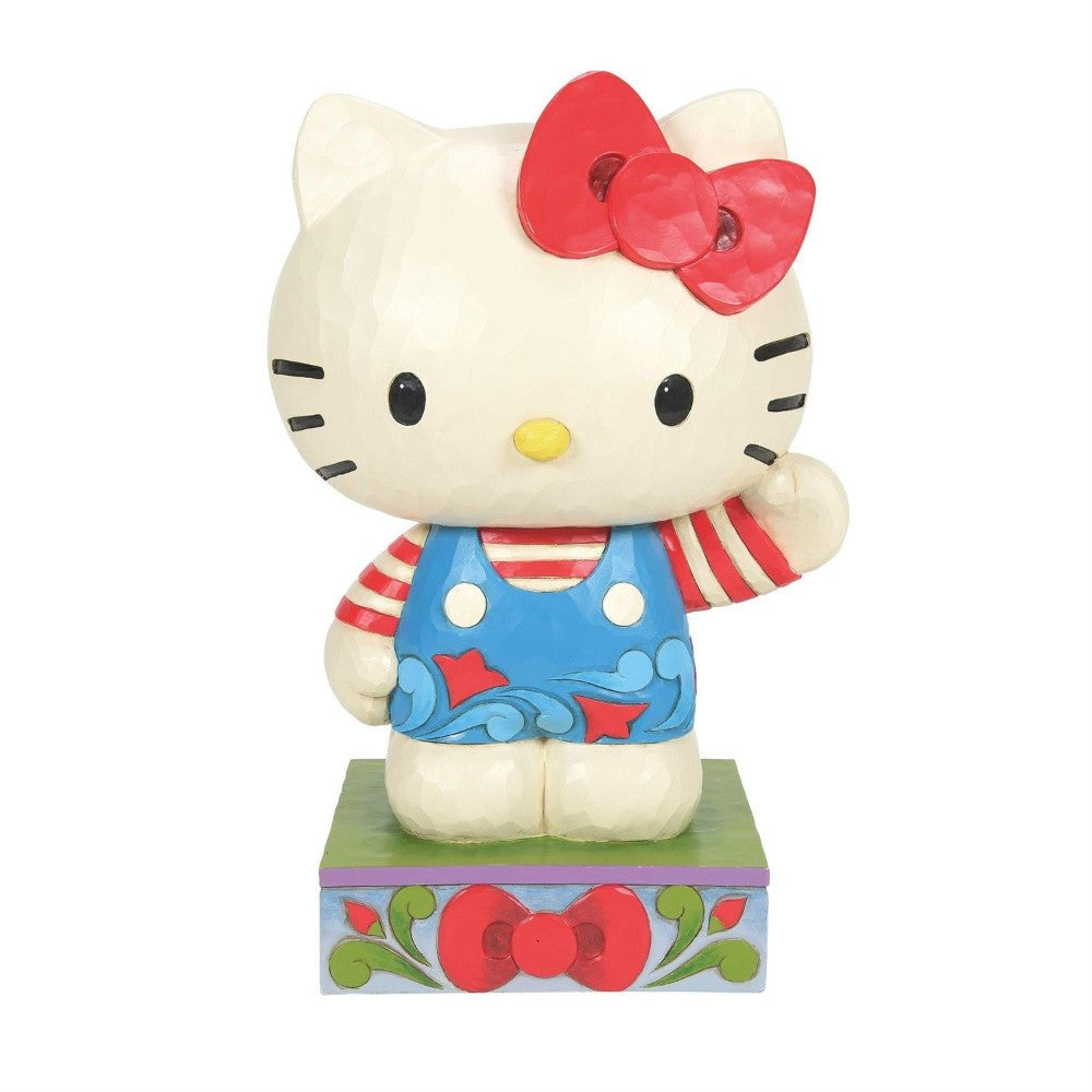 Cartoon cat figurine with red bow and blue overalls.
