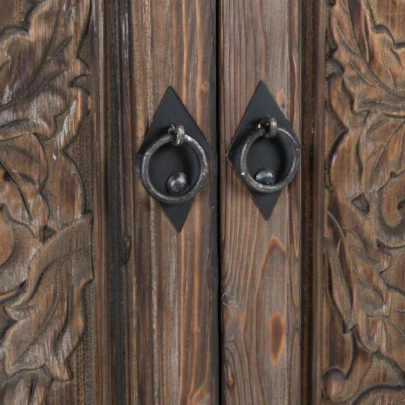 Wooden door with intricate carvings and metal ring handles.