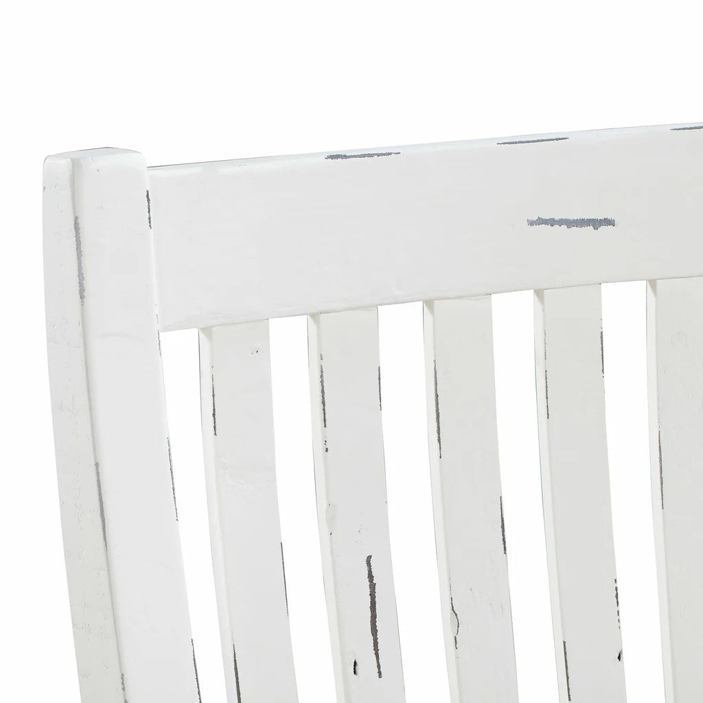 Close-up of a white wooden chair with a distressed finish.