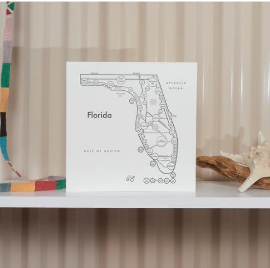 Map illustration of Florida on a shelf with decor items.