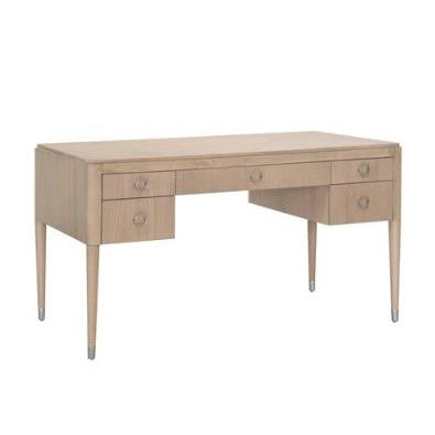 Light wood desk with five drawers and slender legs.