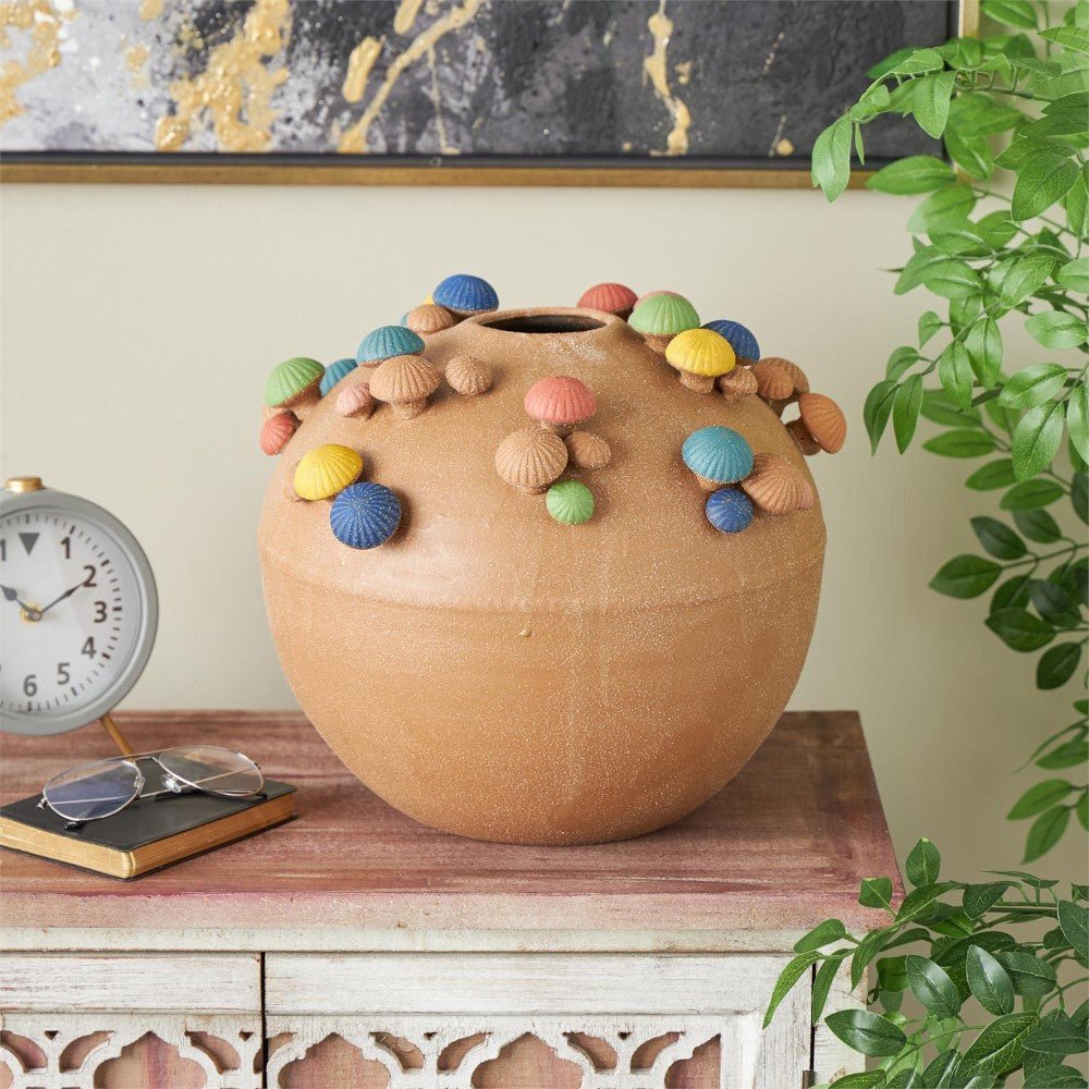 Decorative urn with colorful shell-like adornments on a rustic table.