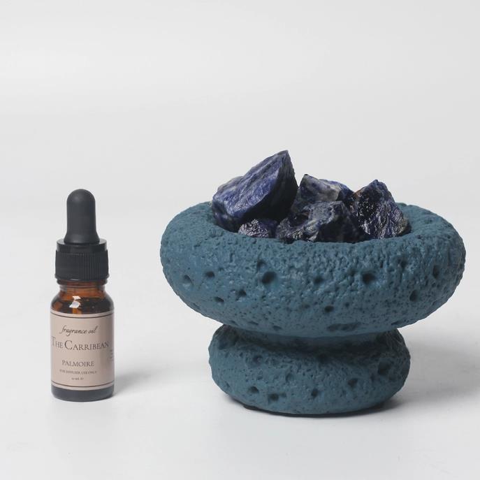 Blue stone holder with rocks and a dropper bottle.