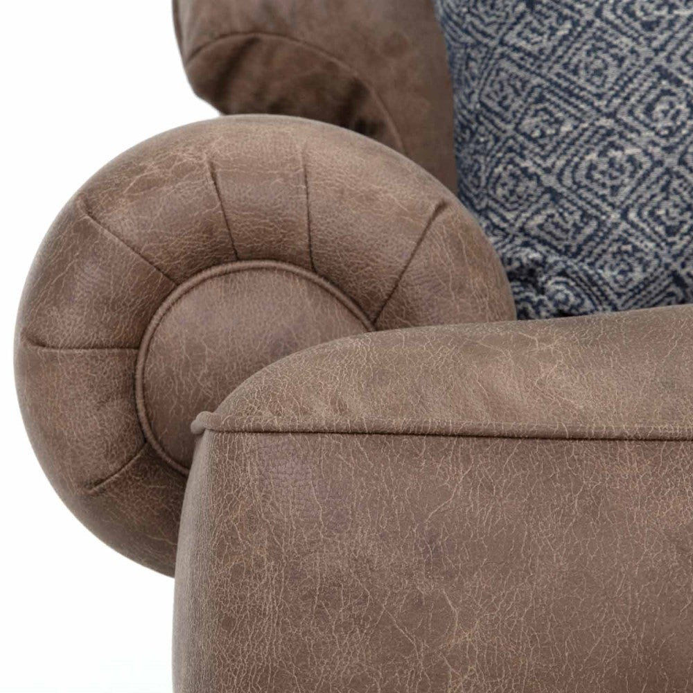 Brown leather chair with a patterned blue cushion.