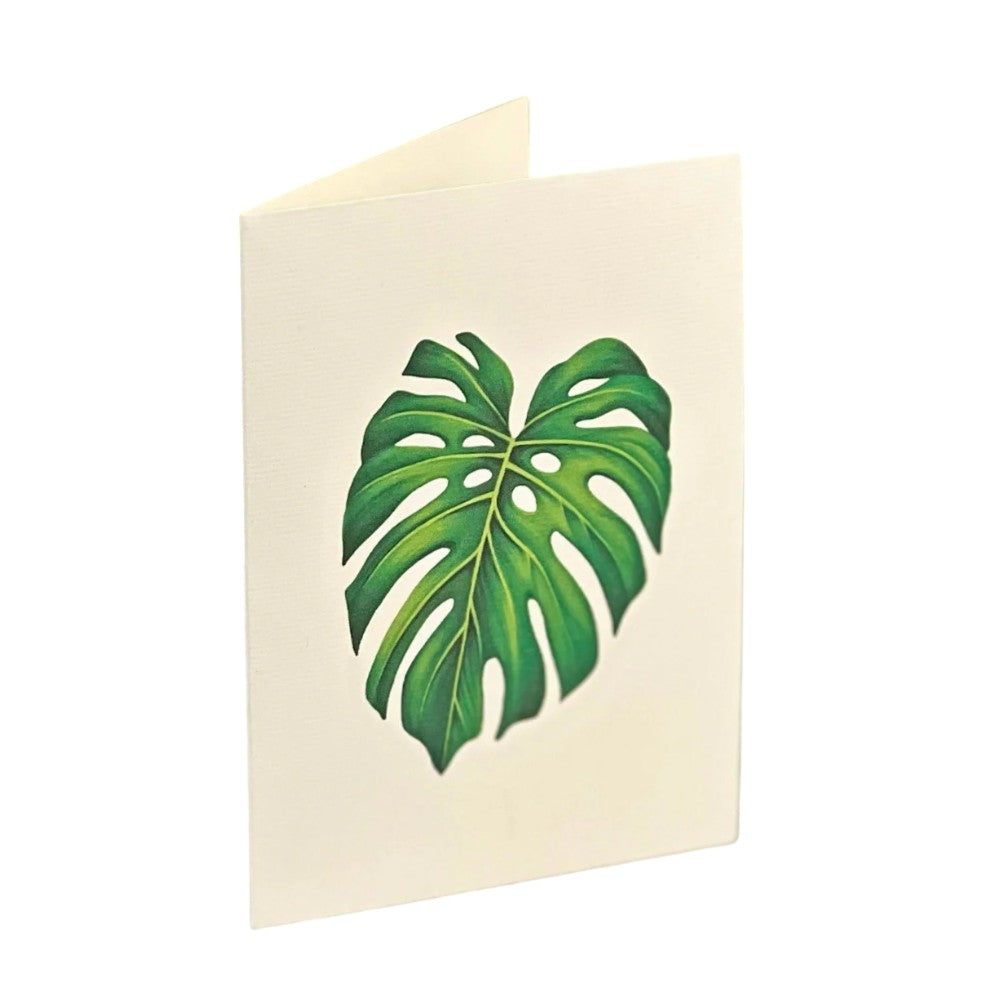 Cream card with a large green monstera leaf design on the front.