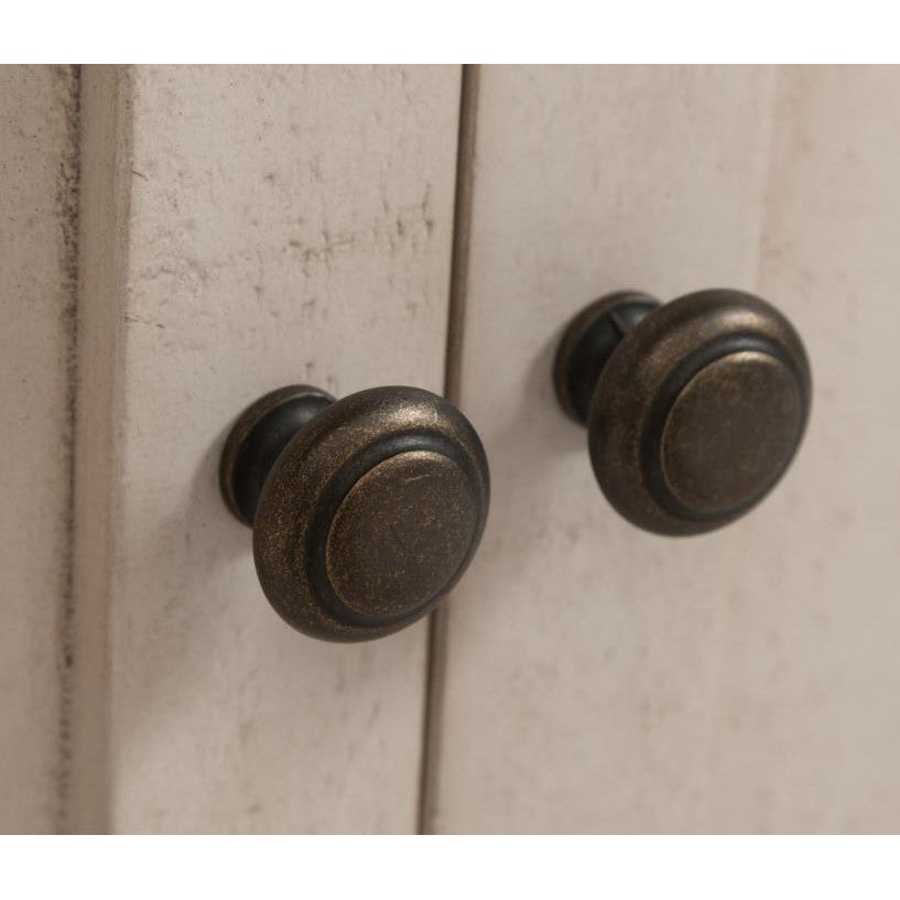 Two rustic cabinet knobs on a wooden surface.
