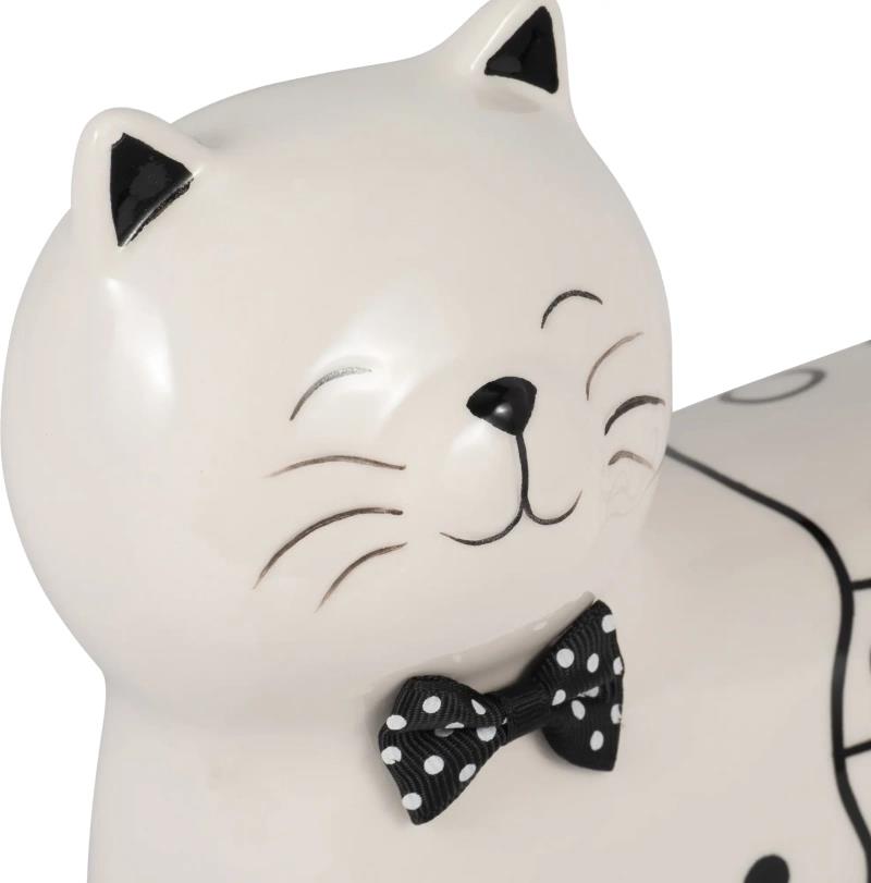 Ceramic cat figure with a polka dot bow tie, smiling contentedly.