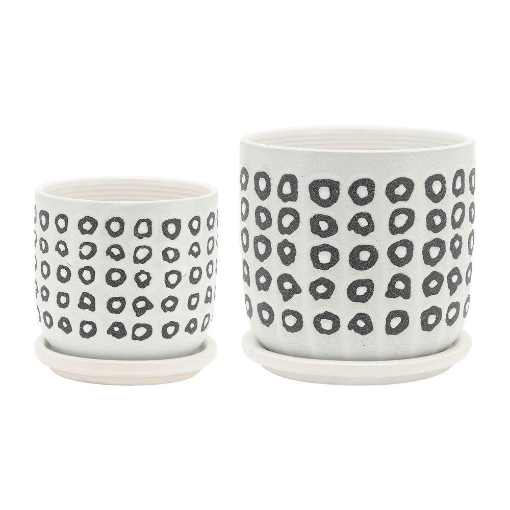 Two white pots with black circle patterns on white saucers.