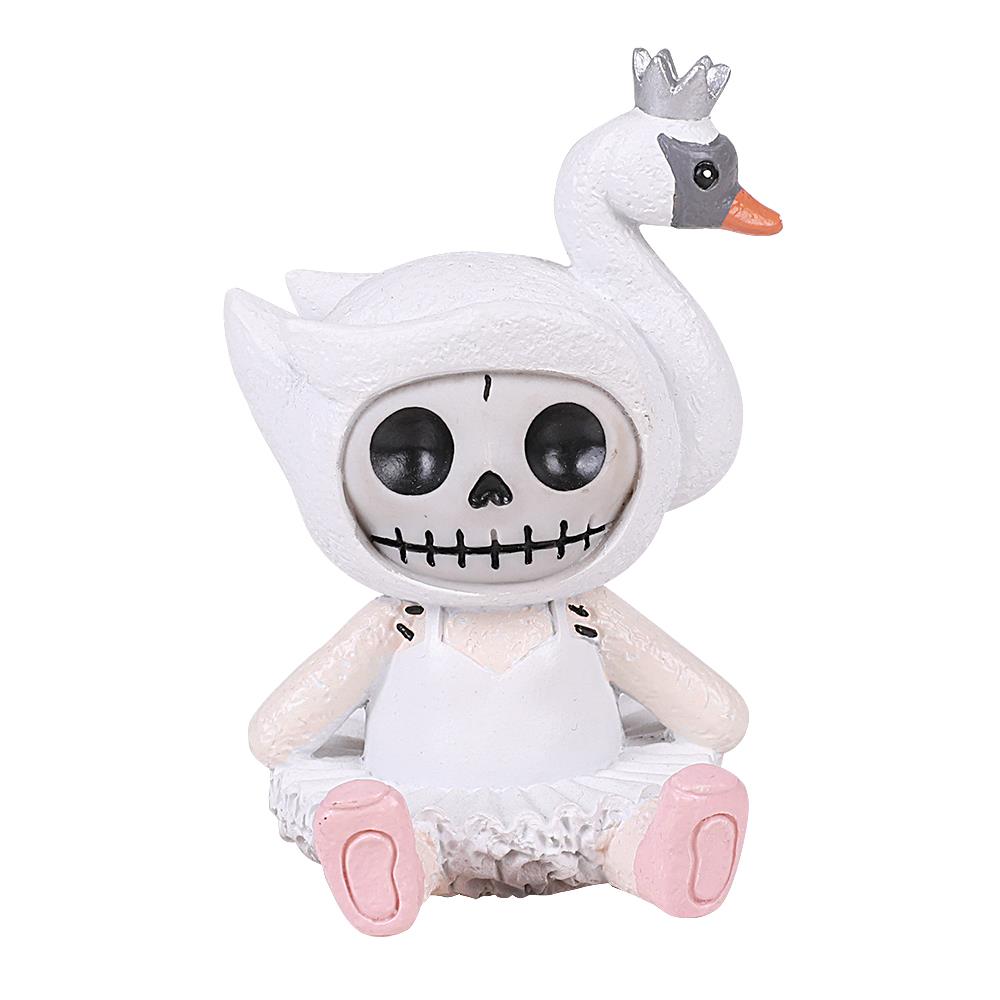 Cute skeleton doll in a swan-themed costume sits with a crown.