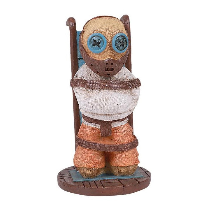 Figurine with button eyes in a straitjacket, strapped to a chair.