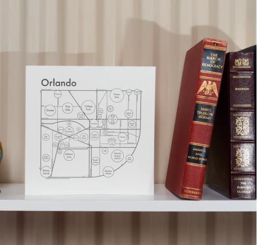 Shelf with a map of Orlando and three books.