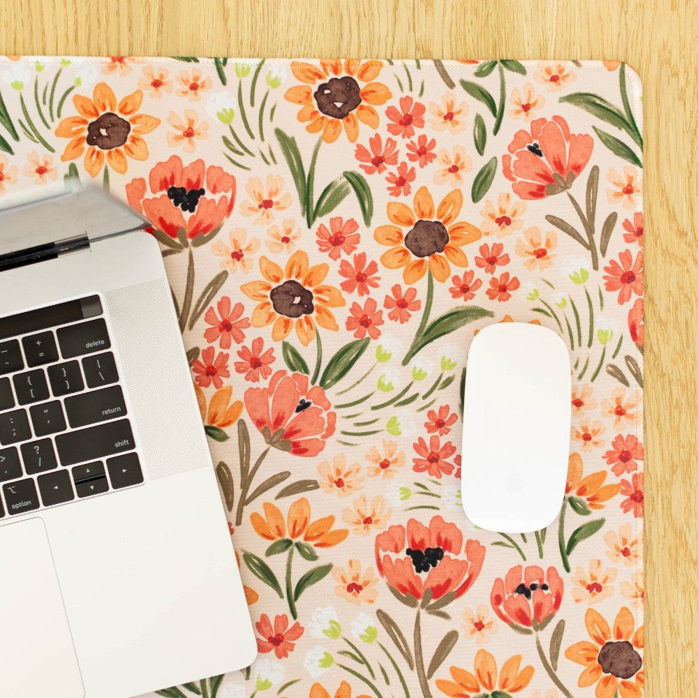 Laptop and mouse on floral print mat.