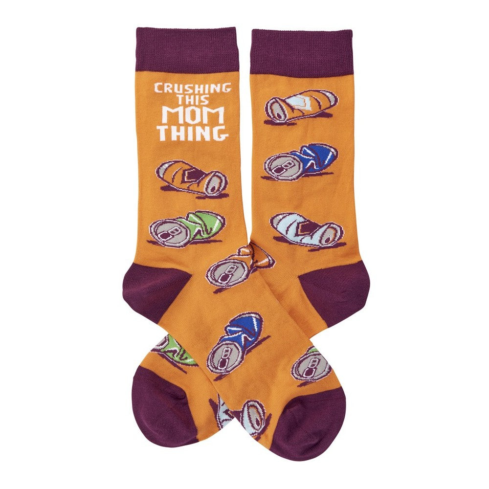 Orange socks with crushed cans and "Crushing This Mom Thing" text.