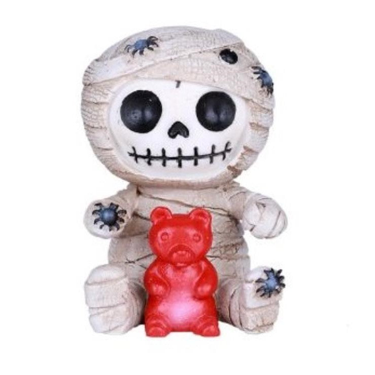 Mummy bear holding a red gummy with blue spiders on its wrappings.
