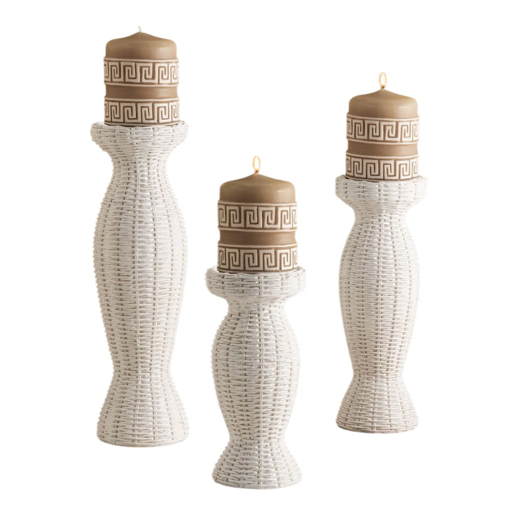 Three white wicker candle holders with Greek key pattern candles.