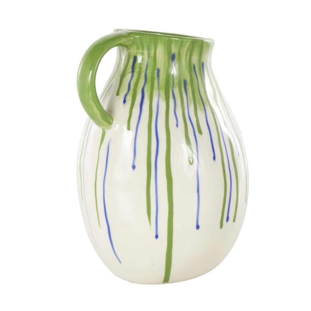 White pitcher with green handle and blue-green drips.