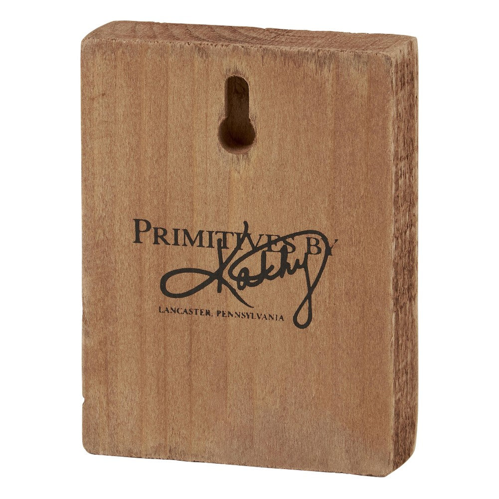 Wooden block with "Primitives by Kathy" logo and hanging hole.