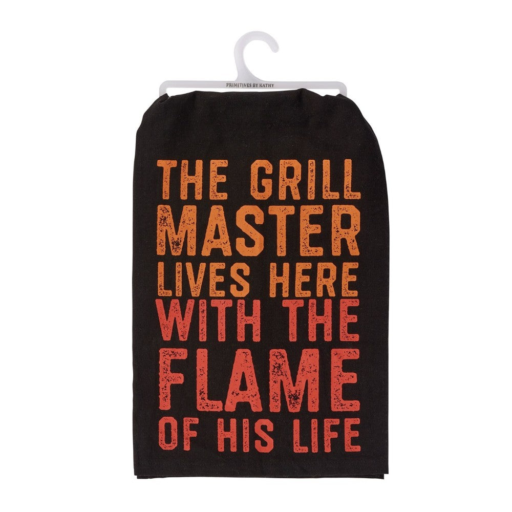 Black towel with orange text: "The grill master lives here with the flame of his life."