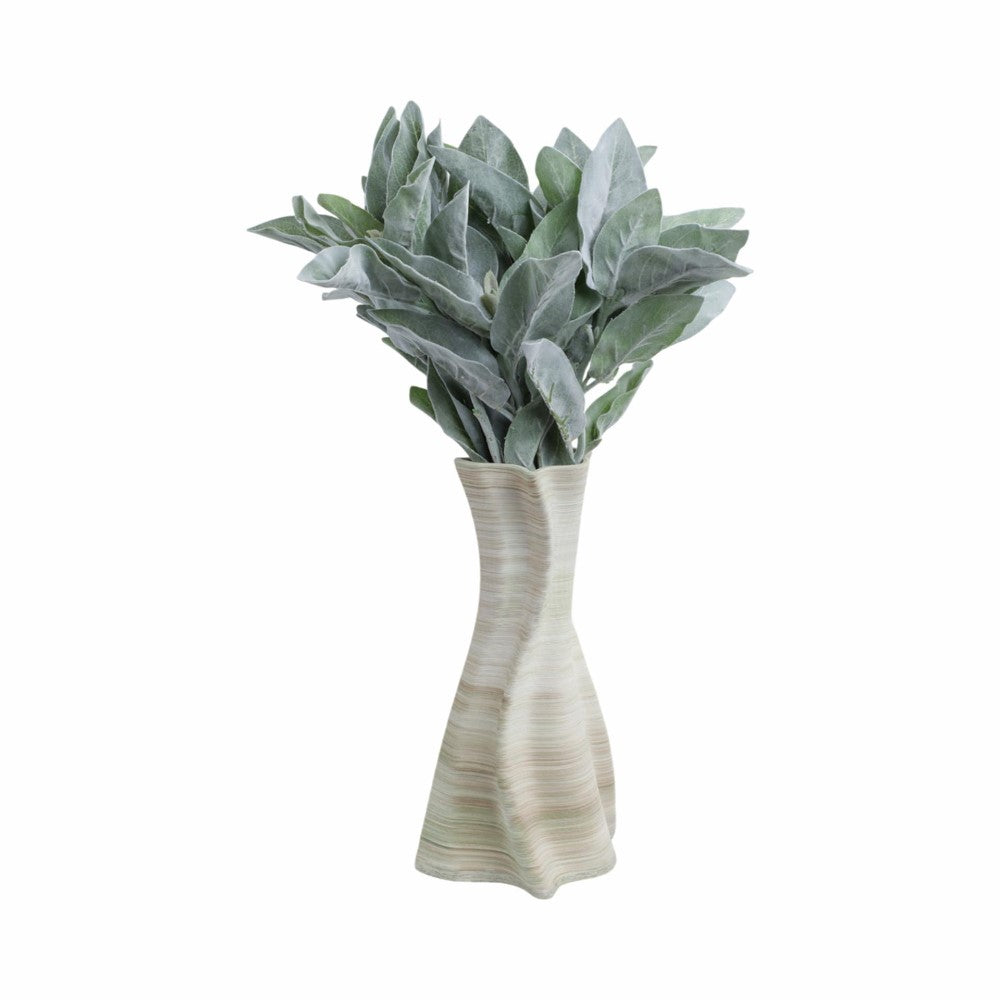 Curved ceramic vase with lush, green leaves.